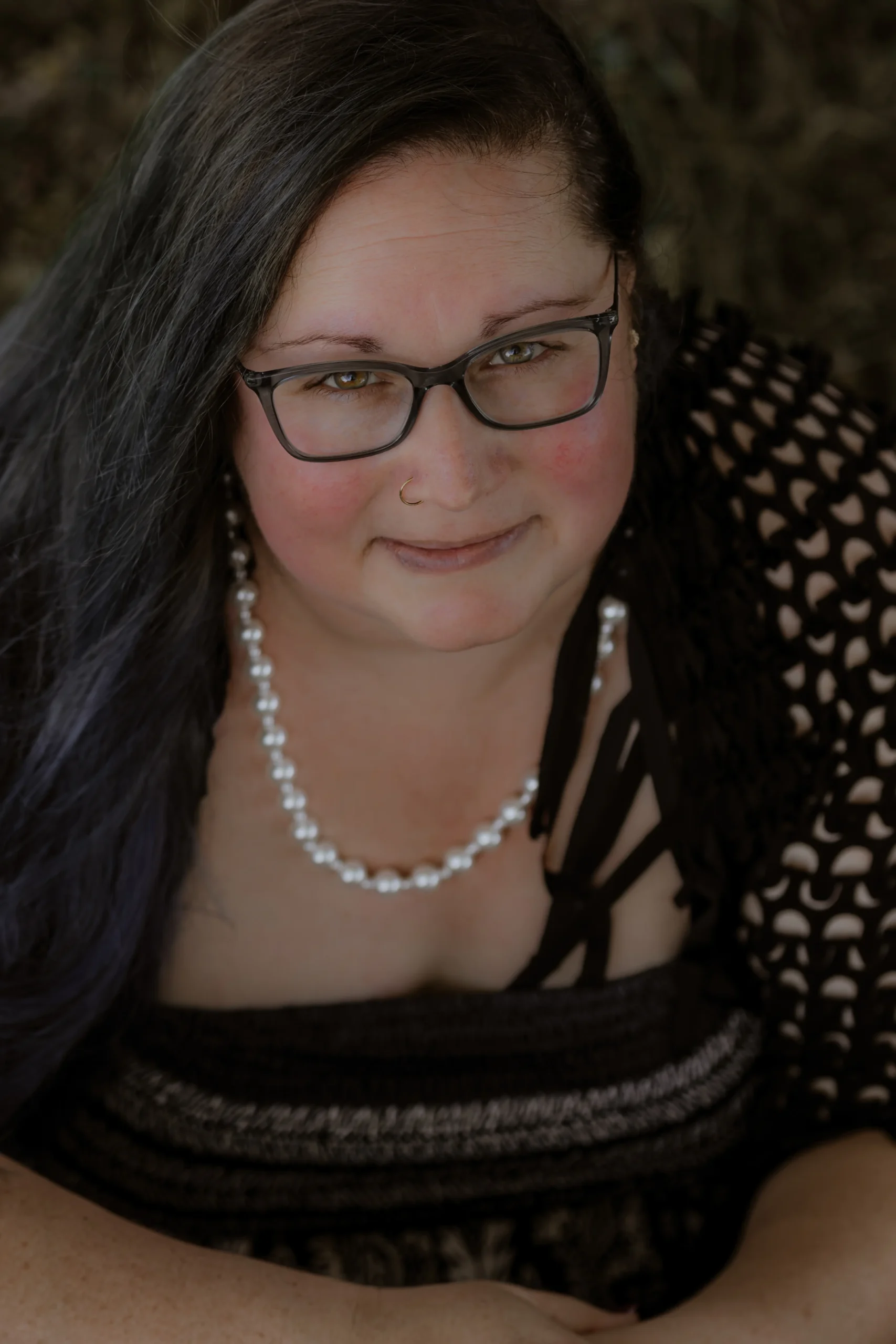 Beth of The Mystic Sisters in a thoughtful outdoor portrait.