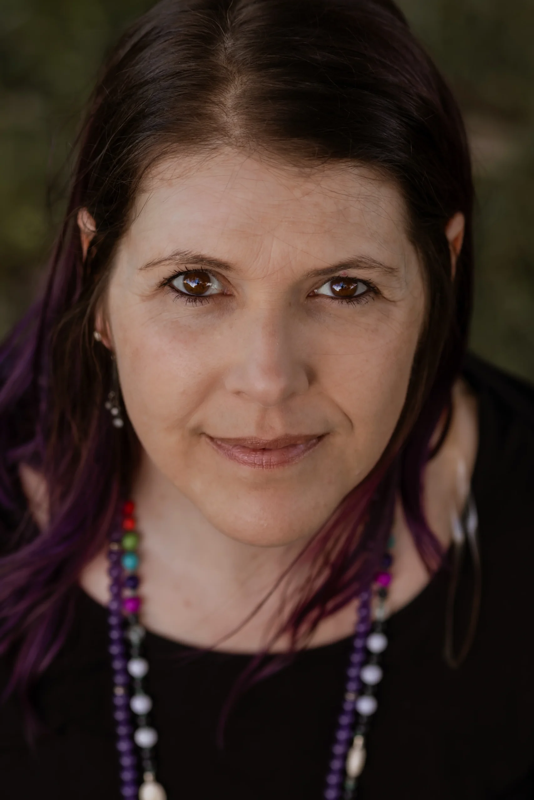 Mandi of The Mystic Sisters in a relaxed outdoor portrait.